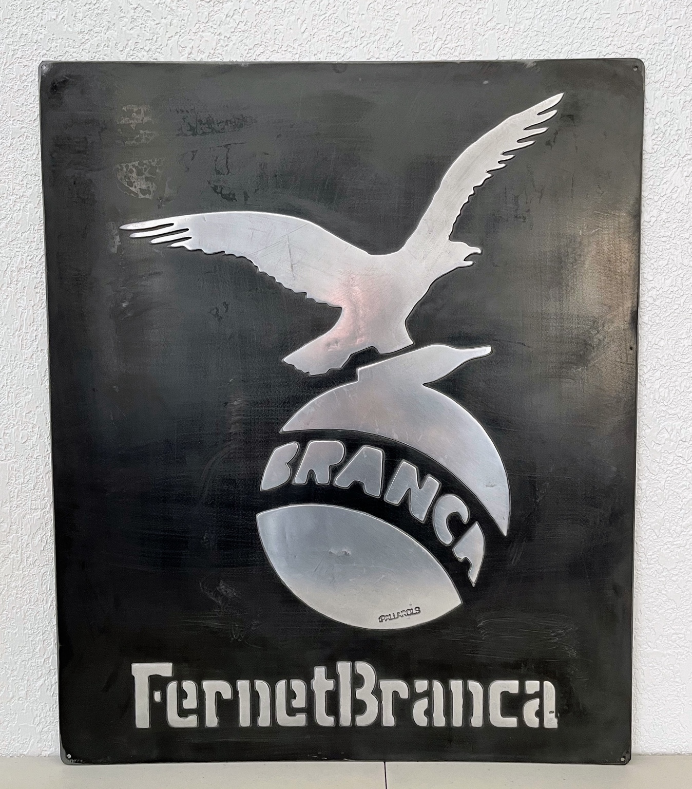 Vista frontal completa de la placa negra Fernet Branca con águila en relieve