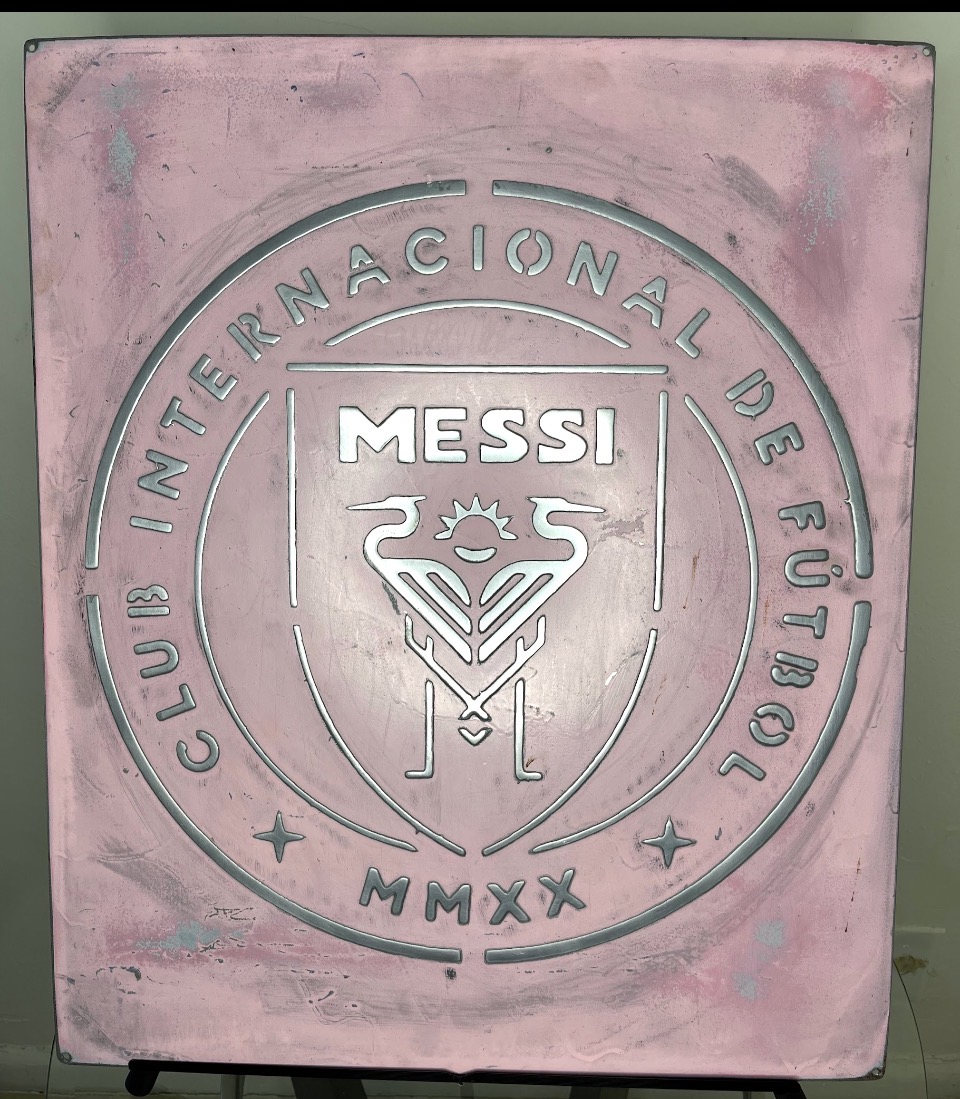 Vista frontal completa de la placa rosa con emblema futbolístico de Messi