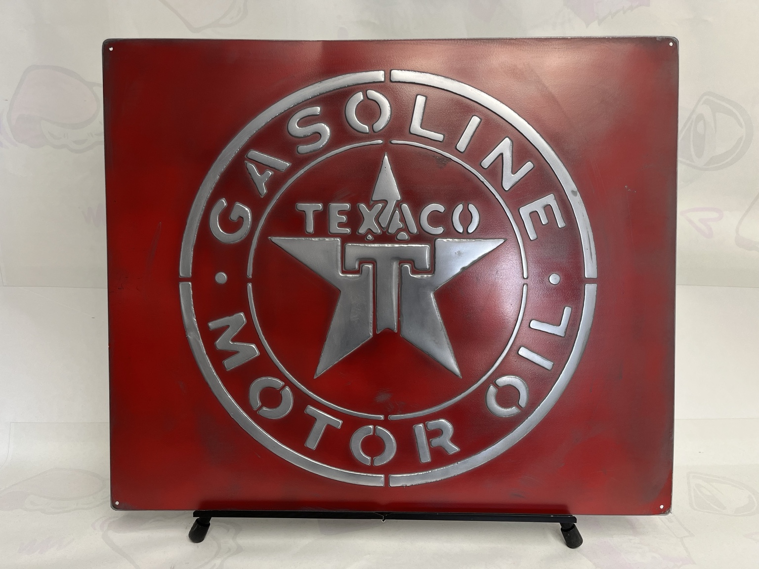 Front view of a red vintage iron sign with raised aluminum relief
